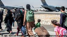 In this image provided by the U.S. Marine Corps, families walk towards their flight during ongoing evacuations at Hamid Karzai International Airport, Kabul, Afghanistan, Tuesday, Aug. 24, 2021. (Sgt. Samuel Ruiz/U.S. Marine Corps via AP)