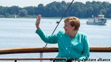 Bundeskanzlerin Angela Merkel (CDU) fährt mit dem bayerischen Ministerpräsidenten Söder (, nicht im Bild, CSU) gemeinsam mit einem Schiff der Chiemsee-Schifffahrt auf die Insel Herrenchiemsee und winkt. (zu dpa Themenpaket zum Ende der Ära Merkel nach der Bundestagswahl)