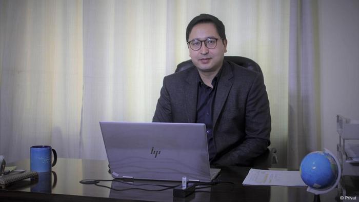 Abdul Ghafoor assis à son bureau avec un ordinateur portable