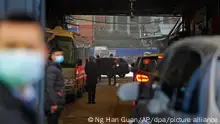 FILE - In this file photo dated Sunday, Jan. 31, 2021, a convoy of vehicles carrying the World Health Organization team enters the interior of the Huanan Seafood Market on the third day of field visit in Wuhan in central China. In a commentary published Wednesday Aug. 25, 2021, the international scientists dispatched to China by the World Health Organization to look for the origins of the coronavirus say the search has â€œstalledâ€ and warn the window is closing to conduct critical studies that could provide clues on how the virus first infected people.(AP Photo/Ng Han Guan, FILE)