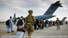 Australian citizens and visa holders prepare to board the Royal Australian Air Force C-17A Globemaster III aircraft, as Australian Army infantry personnel provide security and assist with cargo, at Hamid Karzai International Airport in Kabul, Afghanistan August 22, 2021. SGT Glen McCarthy/ Australia's Department of Defence/Handout via REUTERS. ATTENTION EDITORS - THIS IMAGE WAS PROVIDED BY A THIRD PARTY. NO RESALES. NO ARCHIVES.