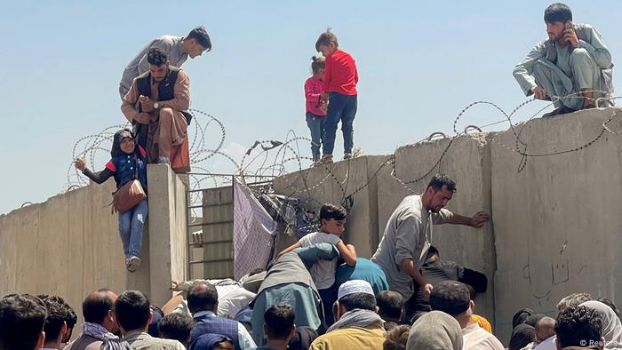 A man pulls a girl to get inside Hamid Karzai International Airport in Kabul, Afghanistan August 16, 2021.