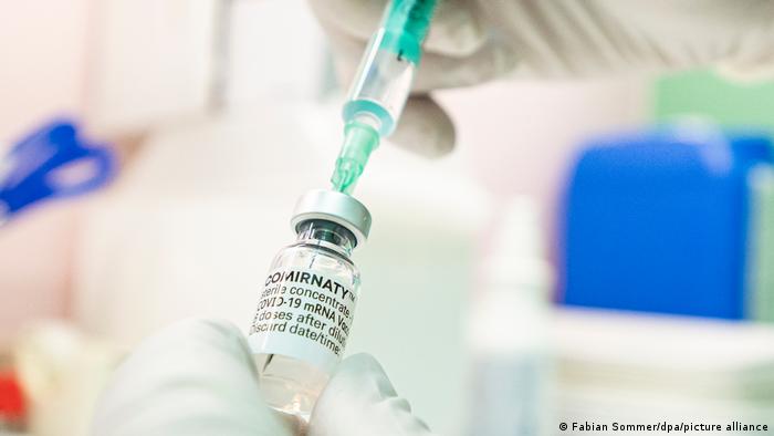 A medical professional draws up the vaccine from a vial of the BioNTech-Pfizer jab 
