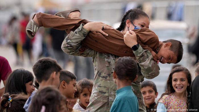 Ein US-Soldat spielt mit kürzlich evakuierten afghanischen Kindern auf dem US-Luftwaffenstützpunkt Ramstein, Deutschland, Dienstag, 24. August 2021.