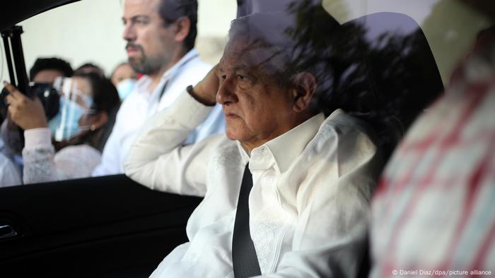 The Mexican president seen in a car with protesters in the background