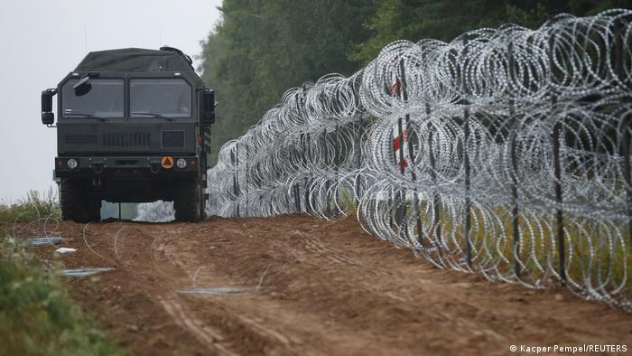 A view of a vehicle next to a fence built by Polish soldiers on the border between Poland and Belarus near the village of Nomiki, Poland August 26, 2021.
