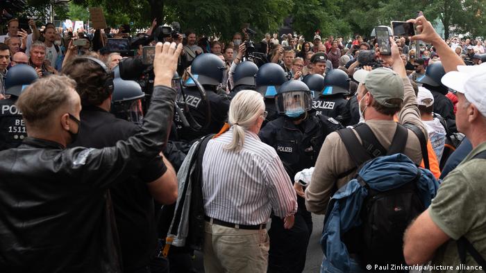 Riot police talk to protesters in a Berlin unhappy about coronavirus rules,