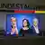 Die Kanzlerkandidaten Armin Laschet, Annalena Baerbock und Olaf Scholz sind nebeneinander auf einem TV-Bildschirm zu sehen, über dem Gerät steht an einer Wand "Bundestagswahl".
