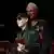 Klaus Meine und Rudolf Schenker stehen an einem Rednerpult, Meine hält eine Auszeichnung in Händen