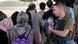 A US Force Airman guides evacuees towards a plane at Kabul airport A US Force Airman guides evacuees towards a plane at Kabul airport