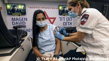 A medic from Israel's Magen David Adom emergency service administers a booster shot of the coronavirus vaccine to a woman in Tel Aviv, Israel, Saturday, Aug. 14, 2021. The country that had appeared to put the coronavirus pandemic behind it a few months ago after a world-leading vaccine drive is now re-imposing regulations in a bid to clamp back down on infections. (AP Photo/Tsafrir Abayov)
