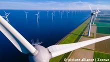 offshore windmill park with clouds and a blue sky, windmill park in the ocean aerial view with wind turbine Flevoland Netherlands Ijsselmeer. Green energy