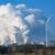 A wind turbine stands in a field in front of a coal-fired power plant in eastern Germany