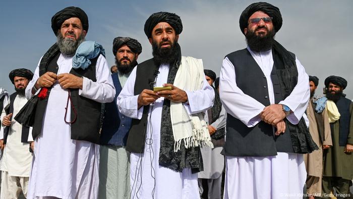 Taliban spokesman Zabihullah Mujahid (C) talking to media at the Kabul airport, together with other members of the group