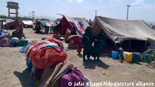 Afghanische Frauen stehen vor ihren Zelten am Rande von Chaman, einer Grenzstadt in der südwestlichen pakistanischen Provinz Belutschistan. Dutzende afghanische Familien haben einen Tag, nachdem die USA ihre 20-jährige Militärpräsenz in dem von den Taliban kontrollierten Land beendeten, die Grenze nach Pakistan überquert. +++ dpa-Bildfunk +++