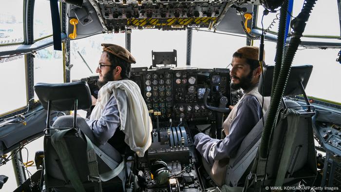 Talibanes sentados en la cabina de un avión de combate afgano.