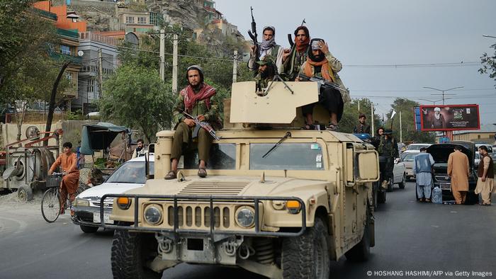 Taliban fighters with machine guns on a Humvee vehicle