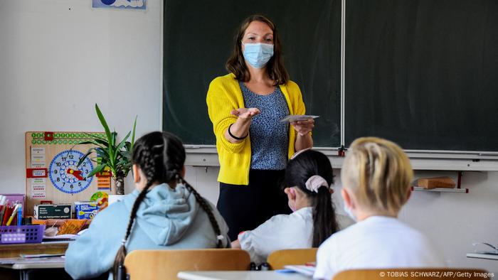 Profesora con mascarilla frente a una clase en una escuela de Berlín