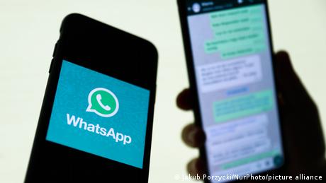 WhatsApp logo displayed on a phone screen and conversation on the WhatsApp displayed on a phone screen in the background are seen in this illustration photo