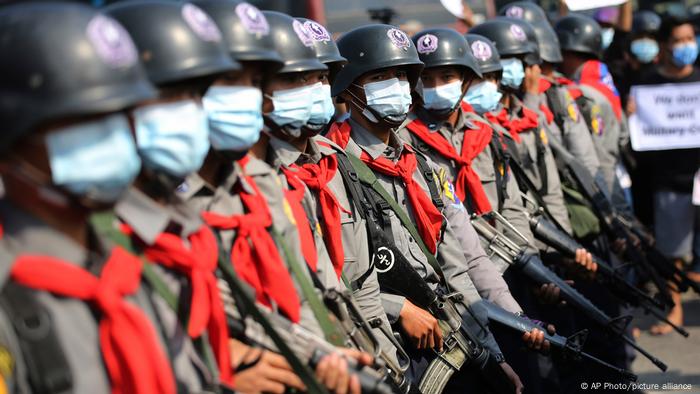 Armed riot police are seen near protesters in Naypyitaw, Myanmar as police fired a water cannon at peaceful protesters