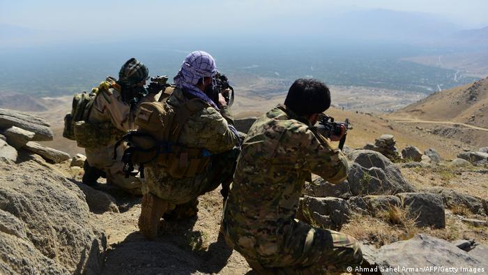 An Afghan resistance movement and anti-Taliban uprising forces take positions during a patrol on a hilltop in Darband area in Anaba district, Panjshir province