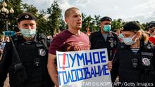 Police officers detain a man with a poster reading Smart voting during an anti-vaccination protest in Moscow on August 14, 2021. - Russia has formally banned organisations established by jailed Kremlin critic Alexei Navalny as the opposition says the authorities are trying to stifle dissent ahead of parliamentary elections. (Photo by Dimitar DILKOFF / AFP) (Photo by DIMITAR DILKOFF/AFP via Getty Images)