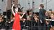 María Dueñas im roten Kleid vor dem Orchester und Dirigent Pietari Inkinen am Pult. María Dueñas im roten Kleid vor dem Orchester und Dirigent Pietari Inkinen am Pult.