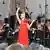 María Dueñas im roten Kleid vor dem Orchester und Dirigent Pietari Inkinen am Pult.
