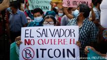 A person holds a sign that reads 'El Salvador doesn't want Bitcoin' as people participate in a protest against the use of Bitcoin as legal tender, in San Salvador, El Salvador, September 7, 2021. REUTERS/Jose Cabezas