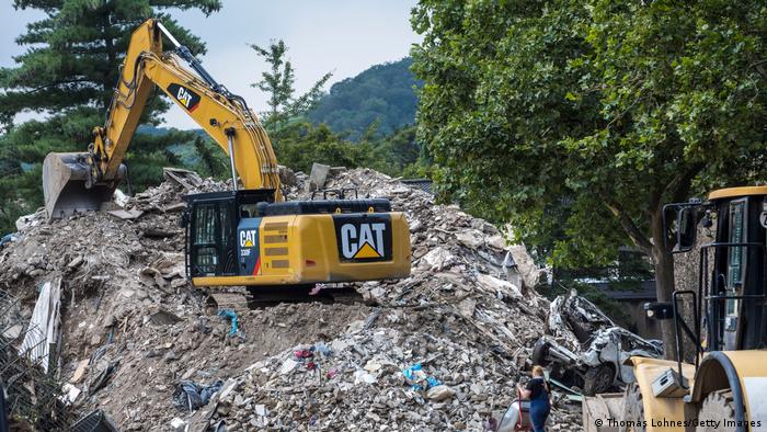 Deutschland | Aufräumarbeiten nach der Flut im Ahrtal. Ein Bagger steht auf einem Müllberg.