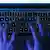 Manos sobre un teclado en la oscuridad: símbolo de ciberataques.