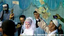 A bride and groom are showered with money as they dance during a wedding in the Egyptian Nile Delta province of al-Minufiyah on May 20, 2016.
Parties to save in 'money pools' have become more common in Egypt in the past few years as economic conditions deteriorate amid the political, security, and economic turmoil in the aftermath of the January 2011 uprising. The idea is to throw as big a party as possible to attract a large crowd and more financial contributions. / AFP / MOHAMED EL-SHAHED (Photo credit should read MOHAMED EL-SHAHED/AFP via Getty Images)