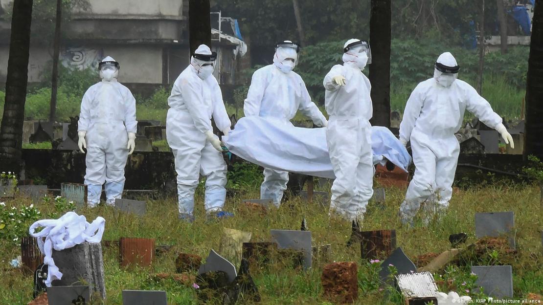 Personas con trajes protectores se preparan para incinerar el cadáver de un niño de 12 años que murió a causa del virus Nipah en la India en septiembre de 2021.