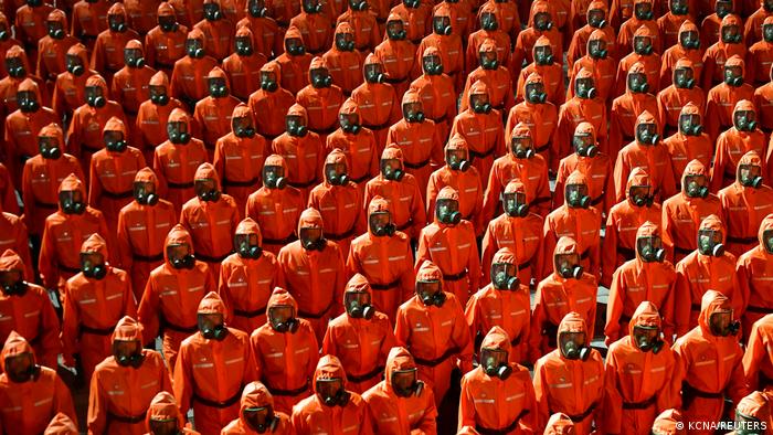 Personnel in orange hazmat suits march during a paramilitary parade held to mark the 73rd founding anniversary of the republic at Kim Il Sung square in Pyongyang in this undated image supplied by North Korea's Korean Central News Agency on September 9, 2021