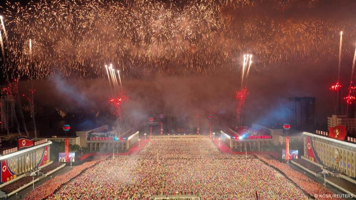 Fuegos artificiales explotan sobre un desfile paramilitar.