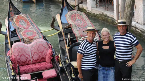 Zwei Gondoliere in Venedig rahmen Giorgia Boscolo ein, die erste Gondelfahrerin nach 900 Jahren.