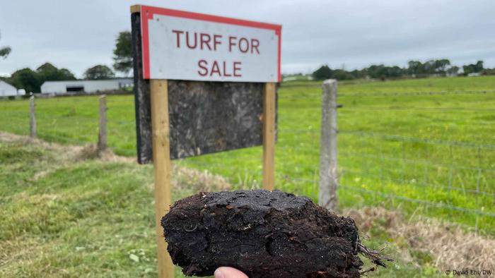 A signpost in a field advertising a place to buy turf