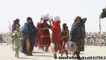 People from Afghanistan walk with their belongings as they cross into Pakistan at the 'Friendship Gate' crossing point, in the Pakistan-Afghanistan border town of Chaman, Pakistan, September 7, 2021. REUTERS/Saeed Ali Achakzai