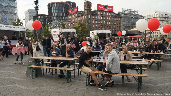 People sitting at tables in a street party