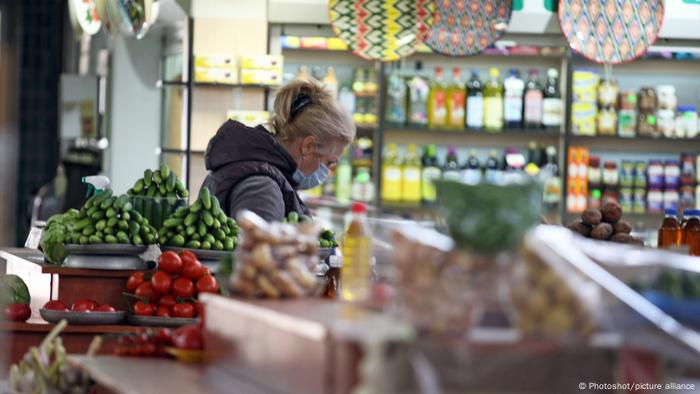 A vendor in a face mask is seen behind a vegetable stall at a market in Kyiv in May 2020