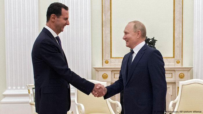 Russian President Vladimir Putin, right, greets Syrian President Bashar Assad