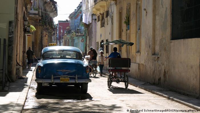 Straßenszene mit Oldtimer und Fahrradtaxi in der Altstadt von Havanna, Kuba, Lateinamerika, Mittelamerika