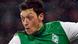 Mesut Oezil lifts his foot high into the air to kick a ball Mesut Oezil lifts his foot high into the air to kick a ball