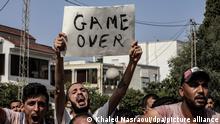 Anhänger des tunesischen Präsidenten Saied skandieren während einer Demonstration vor dem Parlamentsgebäude Slogans gegen Parlamentssprecher und Vorsitzenden der islamistischen Ennahda-Bewegung, Ghannouchi, nachdem Saied die Entlassung von Premierminister Mechichi bekannt gegeben hat. Die Arbeit des Parlaments ist für zunächst 30 Tage eingefroren.