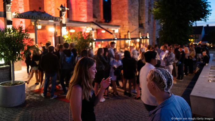 Young Swedes mill in the street outside a cafe in Gotland, Sweden