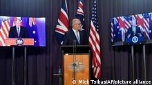 16.9.2021, Canberra****Australia's Prime Minister Scott Morrison, center, appears on stage with video links to Britain's Prime Minister Boris Johnson, left, and U.S. President Joe Biden at a joint press conference at Parliament House in Canberra, Thursday, Sept. 16, 2021. The leaders are announcing a security alliance that will allow for greater sharing of defense capabilities — including helping equip Australia with nuclear-powered submarines. (Mick Tsikas/AAP Image via AP)