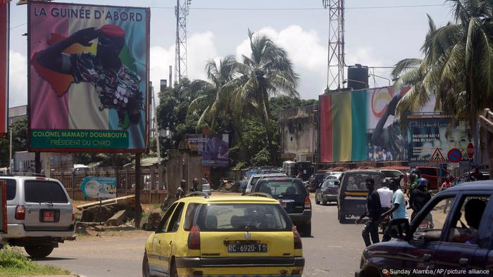 Cars drive past posters of Military junta Mamady Doumbouya in Conakry, Guinea