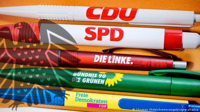 Kugelschreiber der großen Parteien und Schatten des deutschen Bundesadlers...
