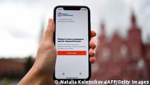 Самартфон с приложением оппозиционного политика Алексея Навального в руке молодого человека