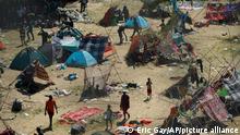 Menschen in einem Lager aus Zelten und improvisierten Notunterkünfte auf staubigem Boden